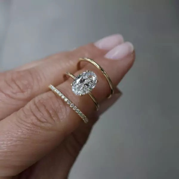 Klassisk tynn diamantring oval i gult gull, på finger